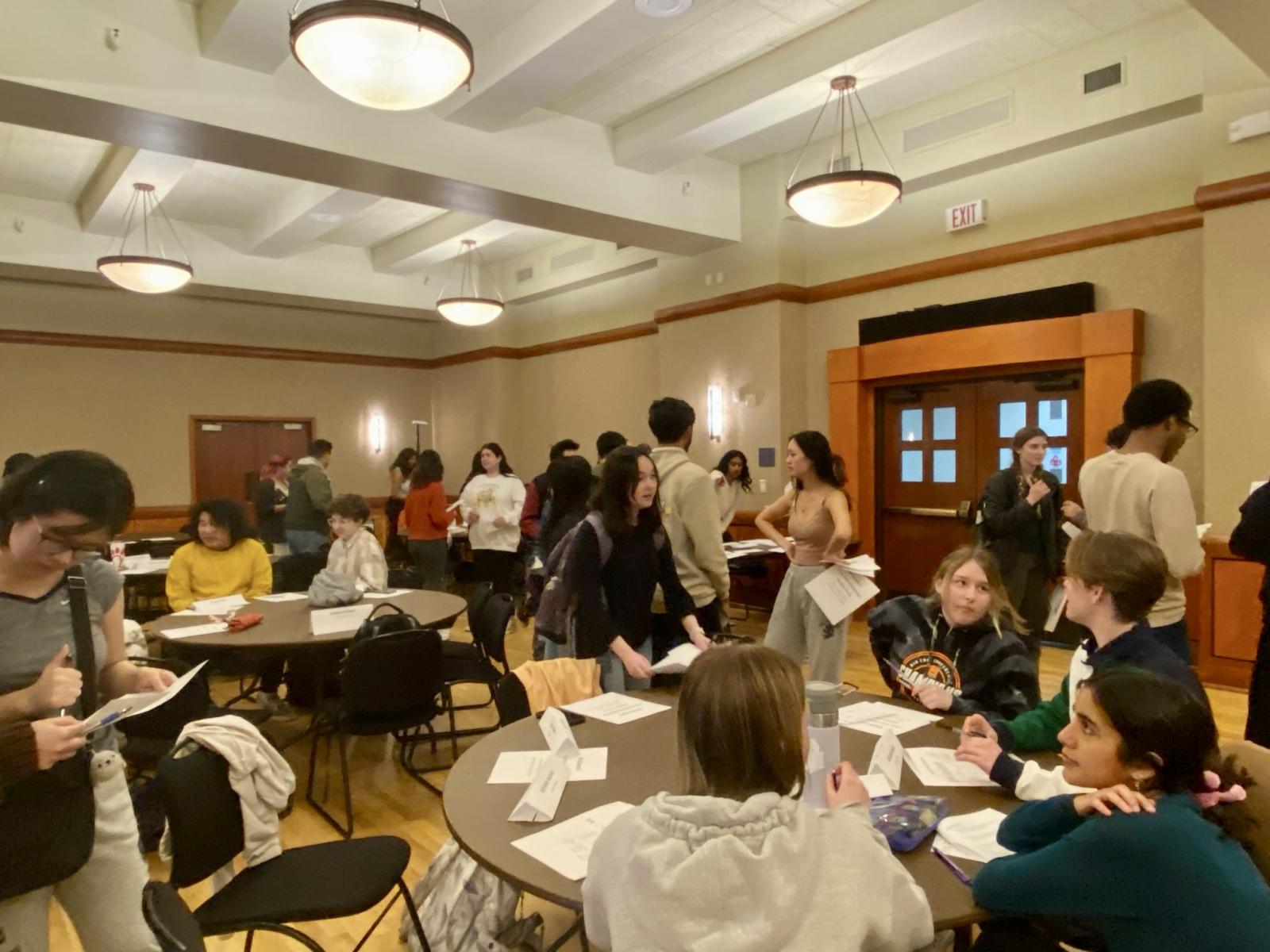 Students sitting and standing and conversing at an SCC event